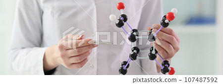 Lab assistant demonstrates molecule model close view 107487592