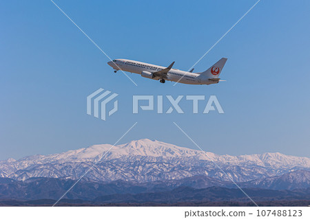 [Komatsu Airport] JAL plane flying over snowy mountains 107488123
