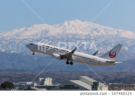 [Komatsu Airport] JAL plane flying over snowy mountains 107488124