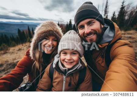 Happy family, Father, mother and son selfie together while hiking on winter high peak mountains. Family activity enjoying to travel together. Generative AI. 107488611