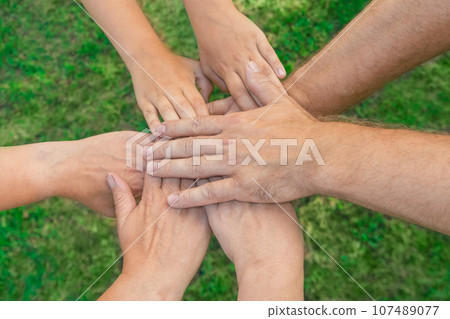 Joined hands as a team. Business teamwork. Close up group of multiracial friends meeting join hands together. Diversity people. Partnership volunteer community. Diverse multiethnic Partners. Top View Joined hands as a team. Business teamwork. Close up group of multiracial friends meeting join hands together. Diversity people. Partnership volunteer community. Diverse multiethnic Partners. Top View 107489077