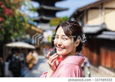 一位身著和服的年輕女子站在五層寶塔的背景下 107489383