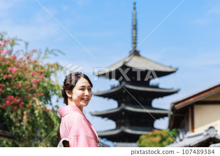 一位身著和服的年輕女子站在五層寶塔的背景下 107489384