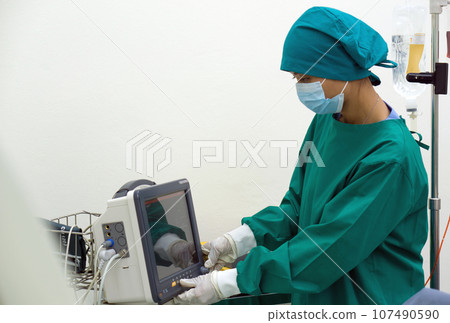 A dedicated healthcare professional in a sterile surgical gown maneuvers a high-tech machine, the latest in medical advancements, underscoring the intersection of technology and medicine. A dedicated healthcare professional in a sterile surgical gown maneuvers a high-tech machine, the latest in medical advancements, underscoring the intersection of technology and medicine. 107490590