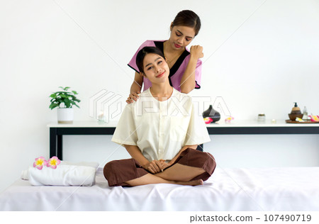Closeup of shoulder stretching. Young pretty woman has thai massage. Calm atmosphere. Concept of serene spa treatments. Closeup of shoulder stretching. Young pretty woman has thai massage. Calm atmosphere. Concept of serene spa treatments. 107490719