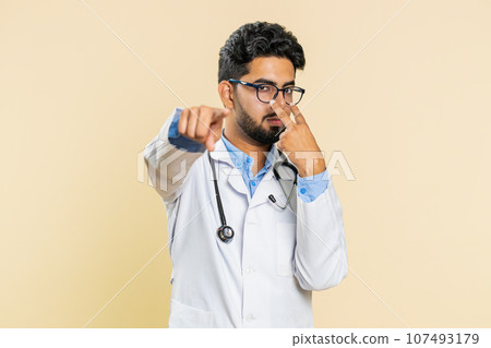 Doctor man pointing at eyes and camera show I am watching you gesture spying, watching on someone 107493179