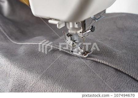 Modern sewing machine with gray velours fabric close up 107494670