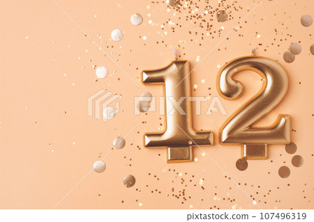 Gold candles in the form of number twelve. 107496319