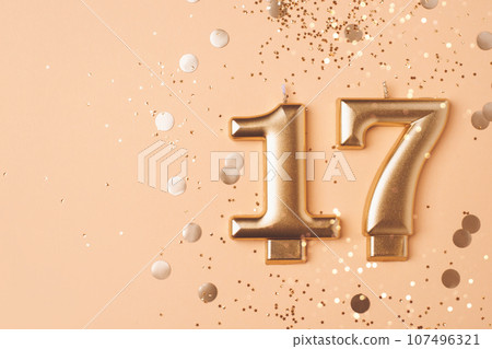 Gold candles in the form of number seventeen. 107496321