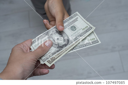 Mother gives his son a pocket money Mother gives his son a pocket money 107497085