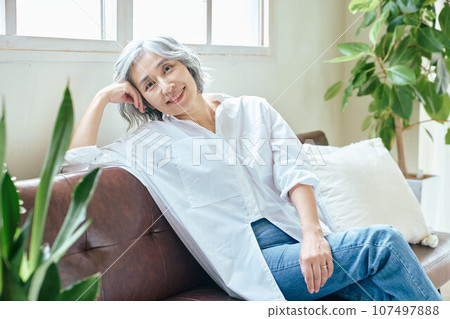 Senior woman relaxing on the sofa 107497888