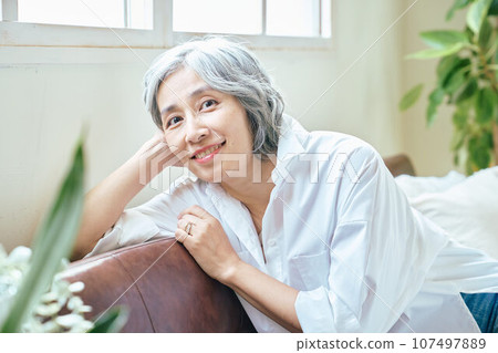 Senior woman relaxing on the sofa 107497889
