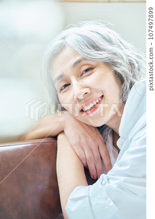 Senior woman relaxing on the sofa 107497899