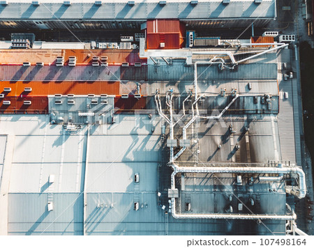 Directly above, looking down at the roof top of distribution center, and pipes going across the roof  107498164