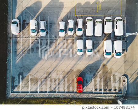 Top down view of a parking lot with generic white cars and one red car Top down view of a parking lot with generic white cars and one red car 107498174