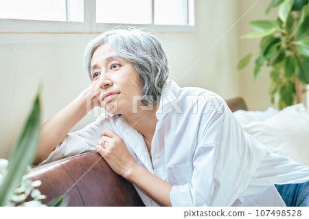 放鬆在沙發上的高級女人 107498528