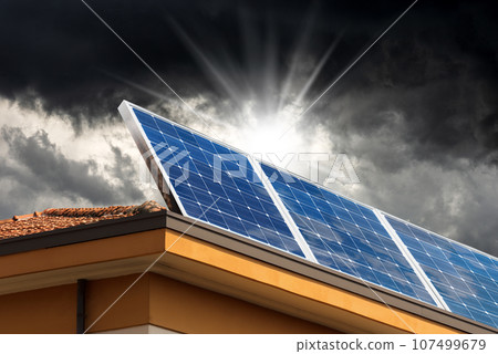 Solar Panels on the Roof of a House with Storm Clouds on Background 107499679