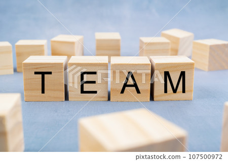 TEAM written on wooden cubes surrounded by a lot of blank cubes on old gray background. TEAM written on wooden cubes surrounded by a lot of blank cubes on old gray background. 107500972