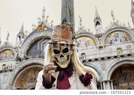 Person dressed up for Carnival of Venice wearing skull mask and white suit Person dressed up for Carnival of Venice wearing skull mask and white suit 107501123