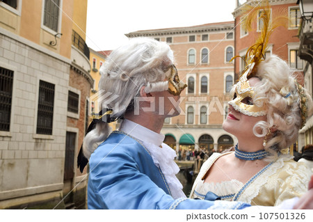 Couple dancing dressed up for Venice Carnival wearing contemporary clothes Couple dancing dressed up for Venice Carnival wearing contemporary clothes 107501326