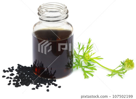 Nigella flower with seeds and essential oil in a glass bottle 107502199