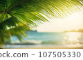 Close-up of palm leaf with blurred tropical beach. 107505330