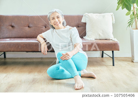 Senior woman relaxing in the living room Senior woman relaxing in the living room 107505406