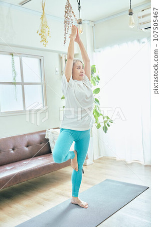 Senior woman doing yoga in the living room 107505467