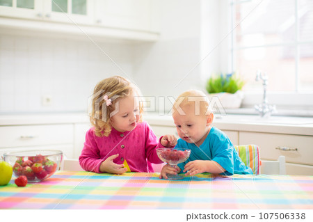 Child eating breakfast. Kid with milk and cereal. 107506338