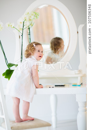 Baby girl looking in mirror Baby girl looking in mirror 107506348
