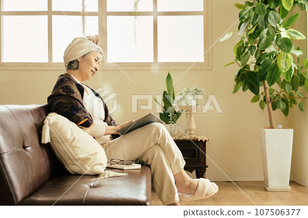 Senior woman touching a tablet in the room Senior woman touching a tablet in the room 107506377
