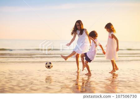 Kids play football on tropical beach at sunset Kids play football on tropical beach at sunset 107506730