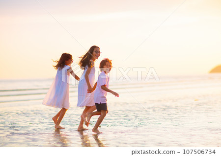 Child playing on ocean beach. Kid at sunset sea. Child playing on ocean beach. Kid at sunset sea. 107506734