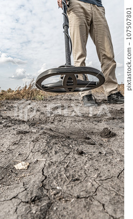 Archaeological and treasure hunting with a metal detector.Hunting for relics in the ground.Search for antiques.Soil research on gold nuggets.A man with a metal detector and a shovel.Finding research Archaeological and treasure hunting with a metal detector.Hunting for relics in the ground.Search for antiques.Soil research on gold nuggets.A man with a metal detector and a shovel.Finding research 107507801