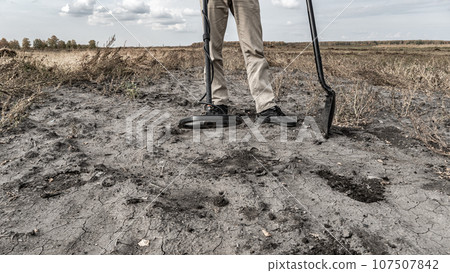 Archaeological and treasure hunting with a metal detector.Hunting for relics in the ground.Search for antiques.Soil research on gold nuggets.A man with a metal detector and a shovel.Finding  research 107507842