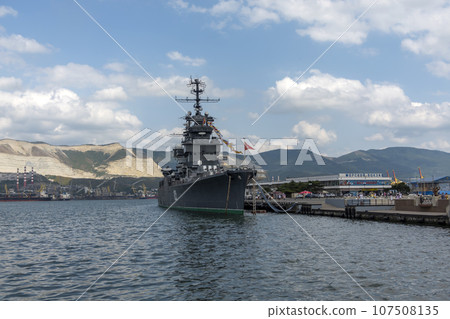 Novorossiysk, Russia - 18 August 2023. Cruiser Mikhail Kutuzov and dolphins, Black Sea, port, Krasnodar Territory, Novorossiysk. Novorossiysk, Russia - 18 August 2023. Cruiser Mikhail Kutuzov and dolphins, Black Sea, port, Krasnodar Territory, Novorossiysk. 107508135