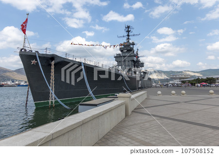 Novorossiysk, Russia - 18 August 2023. Cruiser Mikhail Kutuzov and dolphins, Black Sea, port, Krasnodar Territory, Novorossiysk. Novorossiysk, Russia - 18 August 2023. Cruiser Mikhail Kutuzov and dolphins, Black Sea, port, Krasnodar Territory, Novorossiysk. 107508152