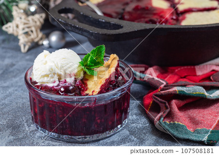 Homemade berry cobbler in glass ramekin with ice cream, Christmas decoration, horizontal Homemade berry cobbler in glass ramekin with ice cream, Christmas decoration, horizontal 107508181