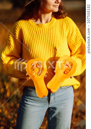 Young woman in a yellow sweater and jeans resting in nature. Fashion, style concept. People, lifestyle. Young woman in a yellow sweater and jeans resting in nature. Fashion, style concept. People, lifestyle. 107508182
