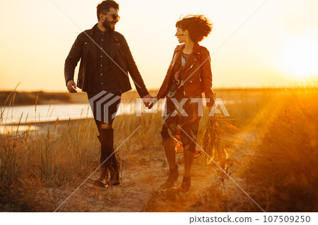 Enjoying time together. Stylish and loving couple enjoying each other by the sea. Enjoying time together. Stylish and loving couple enjoying each other by the sea. 107509250