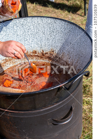 stew cooking in a cauldron, cooking goulash in a cauldron. stew cooking in a cauldron, cooking goulash in a cauldron. 107510839