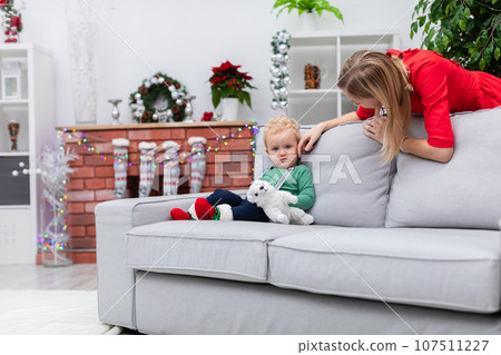 Mom tenderly strokes her baby son's little cheek 107511227