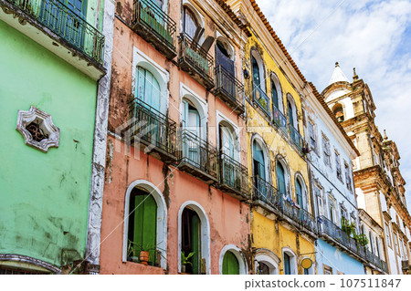 Facades of colorful houses and church 107511847