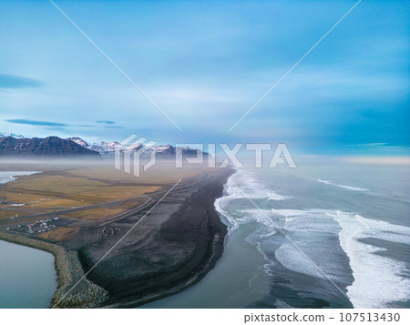 Atlanic shore black sand beach with massive waves crashing on icelandic coastline, majestic natural setting where ocean meets the beach in iceland. Aerial view of gorgeous landscape. Atlanic shore black sand beach with massive waves crashing on icelandic coastline, majestic natural setting where ocean meets the beach in iceland. Aerial view of gorgeous landscape. 107513430