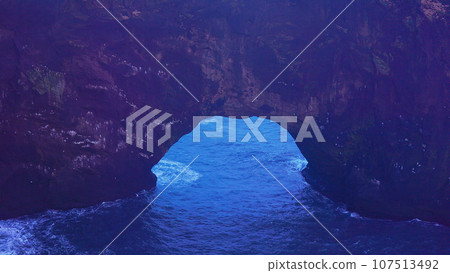 Rocky arch gate on icelandic peninsula, dyrholaey landmark with beautiful natural scenery and stone cliffs. Spectacular coastline rocks with majestic structure, landscapes. Handheld shot. Rocky arch gate on icelandic peninsula, dyrholaey landmark with beautiful natural scenery and stone cliffs. Spectacular coastline rocks with majestic structure, landscapes. Handheld shot. 107513492
