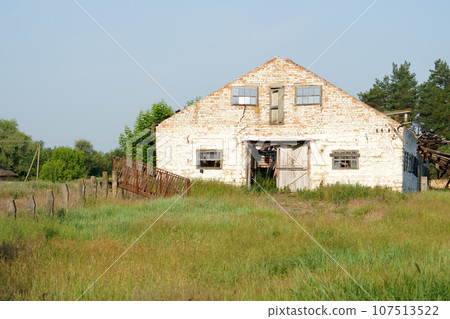 Depressed region of Ukraine. Dilapidation of the village. Untidy old buildings of a livestock farm. View of outskirts and destroyed buildings in village Depressed region of Ukraine. Dilapidation of the village. Untidy old buildings of a livestock farm. View of outskirts and destroyed buildings in village 107513522
