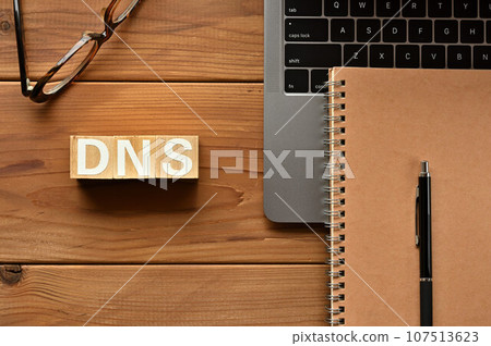 DNS 中排列的木製立方體、電腦、筆記本和筆 107513623