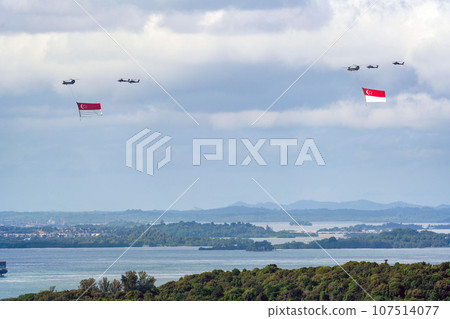 Military helicopter hoisting the national flag on Singapore Independence Day Military helicopter hoisting the national flag on Singapore Independence Day 107514077