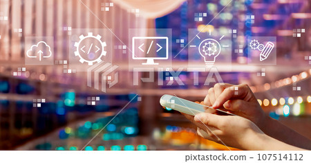 Web development concept with person using a smartphone in city at night Web development concept with person using a smartphone in city at night 107514112