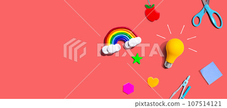 Idea light bulb with a rainbow and school supplies - flat lay 107514121